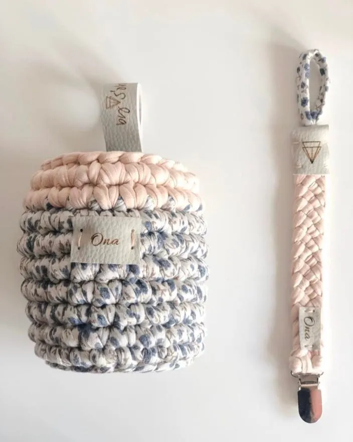 Portabibis y chupetero en rosa empolvado y estampado de flores azules, con el nombre Ona en las etiquetas